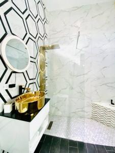 W łazience znajduje się złota umywalka i lustro. w obiekcie Pasavento - Modern Black Suite w mieście Camaceyes