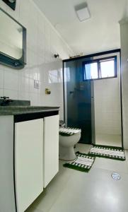 uma casa de banho com um chuveiro e um WC. em Apartamento Praia da Enseada no Guarujá
