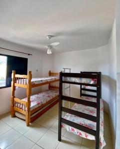 um quarto com 2 beliches e uma ventoinha em Apartamento Praia da Enseada no Guarujá