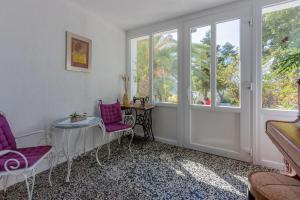 a room with two chairs and a table and windows at Apartment Andry 2 in Crikvenica