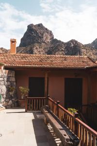 a house with a wooden porch with mountains in the background at Casa rural Los Madroños in Vallehermoso