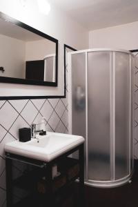 La salle de bains est pourvue d'une douche et d'un lavabo blanc. dans l'établissement Casa rural Los Madroños, à Vallehermoso