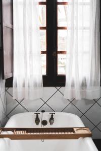 baño con bañera blanca y ventana en Casa rural Los Madroños, en Vallehermoso