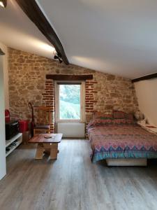a bedroom with a bed and a brick wall at Studette de jeanne in Orléans
