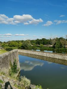 a stone bridge over a river with trees in the background at Studette de jeanne in Orléans