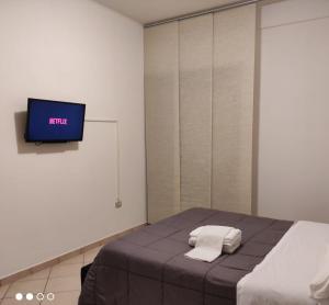 ein Schlafzimmer mit einem Bett und einem TV an der Wand in der Unterkunft Lorenzo B&B House in Battipaglia