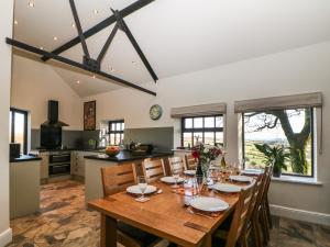 a kitchen and dining room with a wooden table and chairs at The Barn at Hill House in Buxton