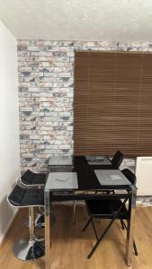 a table with chairs in front of a brick wall at Stunning 1 bedroom apartment in Dagenham in Dagenham