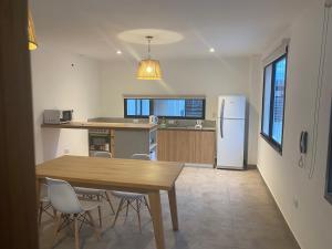 Una cocina con mesa y sillas y un refrigerador. en La Escondida Salta 1, en Salta