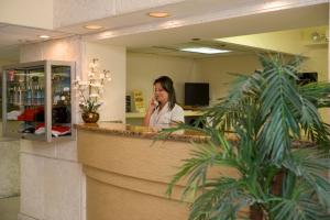 a woman talking on a phone at a counter at Ft. Lauderdale Beach, a VRI resort in Fort Lauderdale