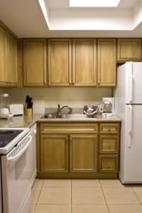a kitchen with wooden cabinets and a white refrigerator at Ft. Lauderdale Beach, a VRI resort in Fort Lauderdale