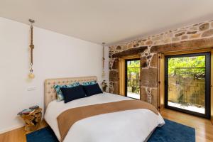 a bedroom with a large bed and a stone wall at Casas Casal de Nino in Celorico de Basto +70 photos