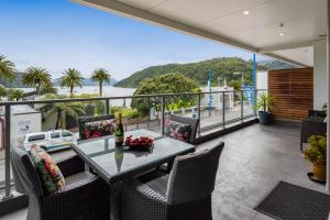 a table and chairs on a balcony with a view of the ocean at No 3 @ The Quay in Picton