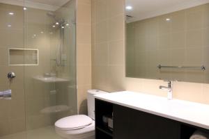 La salle de bains est pourvue de toilettes, d'un lavabo et d'une douche. dans l'établissement Carlyle Suites & Apartments, à Wagga Wagga