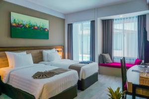 een hotelkamer met twee bedden en een raam bij Royal Regantris Trawangan in Gili Trawangan