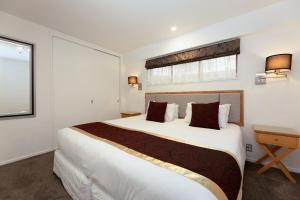 um quarto com uma cama grande e uma janela em Fino Hotel & Suites em Christchurch