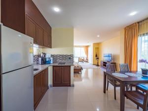 eine Küche mit einem Kühlschrank und einem Tisch mit Stühlen in der Unterkunft Condo AVANTA Deluxe A201 in Ban Tai