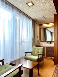 - un salon avec un canapé, une table et un miroir dans l'établissement 雅竹Miyabitake, à Yugawara