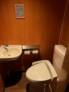 La salle de bains est pourvue de toilettes blanches et d'un lavabo. dans l'établissement 雅竹Miyabitake, à Yugawara