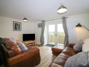 ein Wohnzimmer mit 2 Sofas und einem TV in der Unterkunft Sportsmans Lodge in Kirriemuir