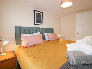 a bedroom with a large bed with two pink pillows at Sportsmans Lodge in Kirriemuir