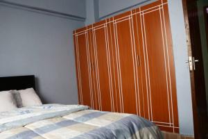 1 dormitorio con un gran armario de madera junto a una cama en Tazama place en Nyeri