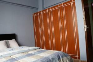 a bedroom with a large wooden cabinet next to a bed at Tazama place in Nyeri