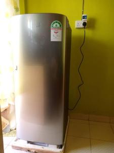 einem Kühlschrank aus Edelstahl in einer Küche neben einer Wand in der Unterkunft Tazama place in Nyeri