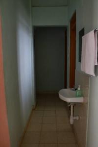 a bathroom with a white sink and a hallway at Tazama place in Nyeri