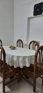 una mesa con 2 sillas y un mantel blanco en Tharavad Holiday Home, en Mangalore
