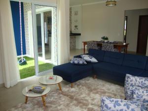 a living room with a blue couch and a table at Minha Casinha Azul na Represa in Paranapanema