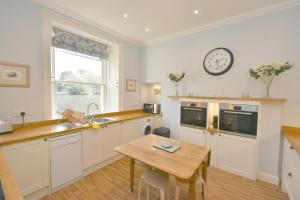 a kitchen with a table and a clock on the wall at West Deyne in Dundee