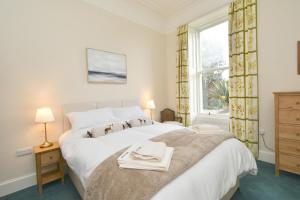 um quarto com uma grande cama branca e uma janela em West Deyne em Dundee