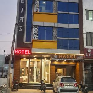 a hotel with cars parked in front of it at Hotel Teeja's - Haldi Restaurant Aiims road Jodhpur in Jodhpur