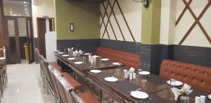 a dining room with a long table and chairs at Hotel Teeja's - Haldi Restaurant Aiims road Jodhpur in Jodhpur