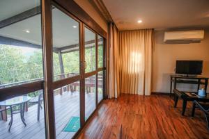 a living room with sliding glass doors and a balcony at Hua Hin Home Hill in Hua Hin
