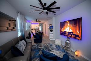 ein Wohnzimmer mit einem Sofa und einem Kamin in der Unterkunft Brand New Modern Pet Friendly Zen Home with Private Home Theater & Hot Tub! home in Orlando