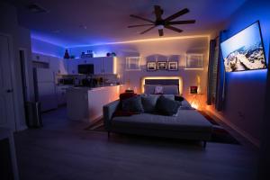 un salon avec un canapé et un ventilateur de plafond dans l'établissement Pet Friendly Modern Zen Studio Retreat with Hot Tub! home, à Orlando
