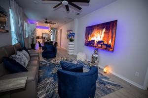 a living room with blue couches and a fireplace at Newly Constructed Modern Pet Friendly Zen Home with Private Home Theater & Hot Tub! home in Orlando