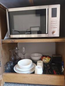 a microwave oven sitting on top of a shelf at Chez Vous French Farmhouse Villa 4 in Pokolbin