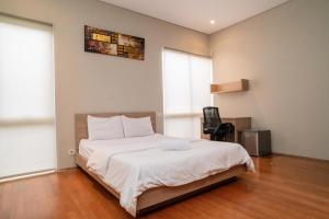una camera da letto con un letto e una sedia di Three J Residence a Tangerang
