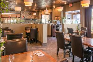 a restaurant with tables and chairs and a bar at Hilltop Inn - Salmon Arm in Salmon Arm