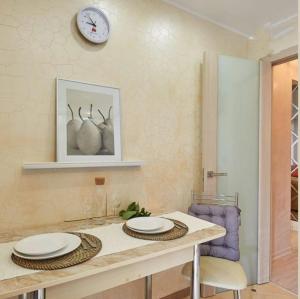 una cocina con una mesa con platos y un reloj en la pared en Шикарные апартаменты в центре en Perm
