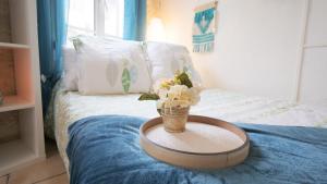 a table with a vase with flowers on a bed at Charmant studio 25 m2 centre ville Avignon in Avignon