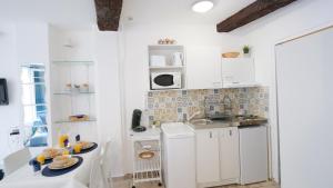 uma pequena cozinha com armários brancos e um lavatório em Charmant studio 25 m2 centre ville Avignon em Avignon