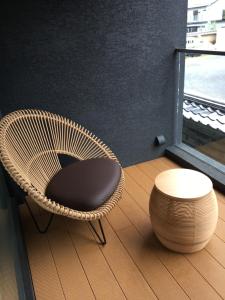 a rattan chair and a stool next to a window at Kikokutei Bekkan in Kyoto