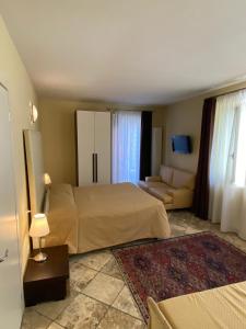 Habitación de hotel con cama y sofá en Il Ghetto Farm Holiday, en Soiano del Lago
