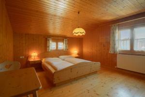1 dormitorio con 1 cama en una habitación de madera en Lari Fari, en Faschina