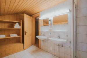ein Bad mit 2 Waschbecken in einem Zimmer in der Unterkunft Lari Fari in Faschina