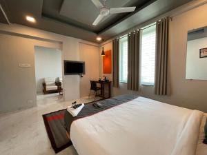 a bedroom with a large bed and a flat screen tv at Manomay Homes in Nagpur